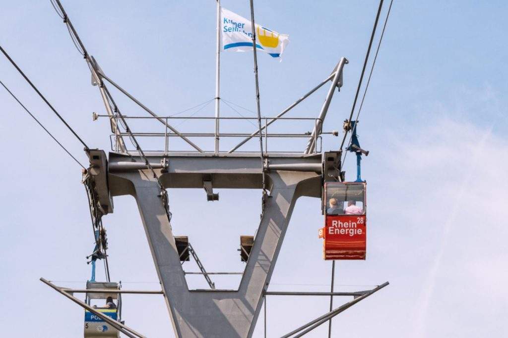 Auf einer Gondel der Seilbahn in Köln zum Rheinpark ist das Logo von RheinEnergie zu sehen.