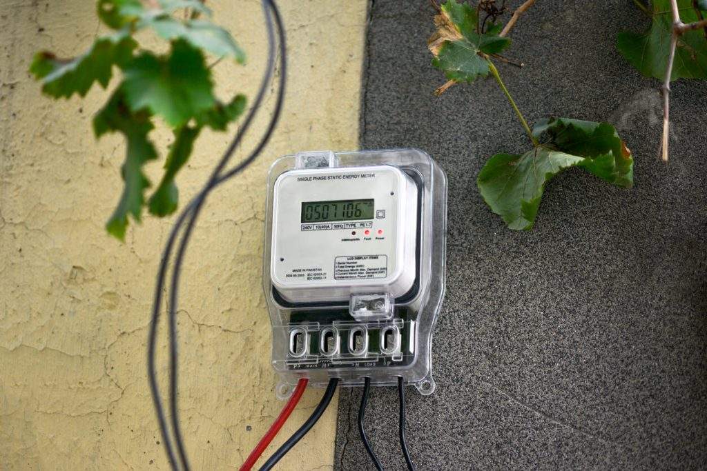 Smart Meter hängt an einer Wand mit Pflanzen